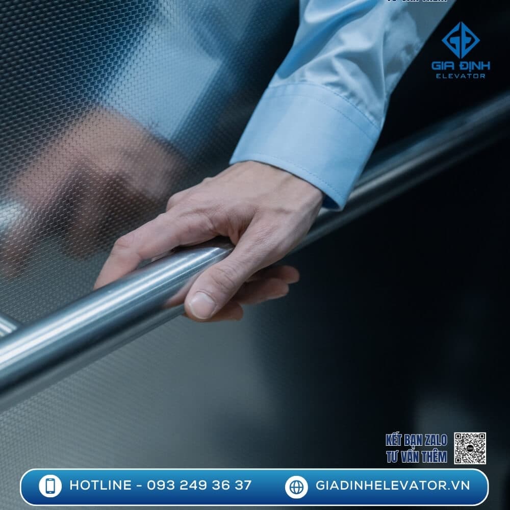 Hình ảnh người dùng đặt tay lên tay vịn của thang máy mini, thể hiện độ bền chắc và an toàn khi sử dụng.